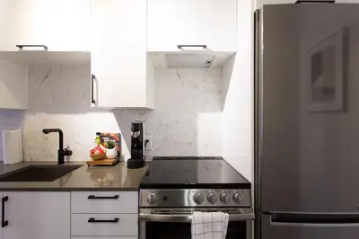 a kitchen with a stove and a refrigerator at Perfect Business Trip Studio with Full Amenities by Den Stays in Montréal