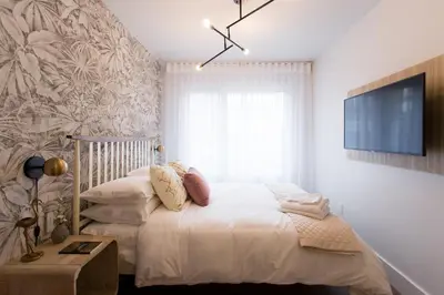 a bedroom with a bed with a tv on the wall at Perfect Business Trip Studio with Full Amenities by Den Stays in Montréal