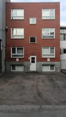 an empty parking lot in front of a brick building at Perfect Business Trip Studio with Full Amenities by Den Stays in Montréal