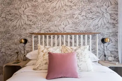 a bedroom with a white bed with a pink pillow at Perfect Business Trip Studio with Full Amenities by Den Stays in Montréal