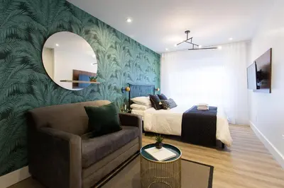 a bedroom with a bed and a chair and a mirror at Blue Tropics Studio in Little Italy with kitchen by Den Stays in Montréal