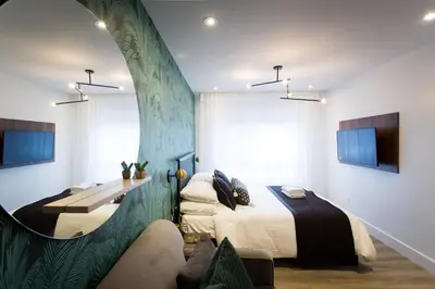a bedroom with a bed and a table and a couch at Blue Tropics Studio in Little Italy with kitchen by Den Stays in Montréal