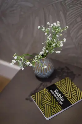 a vase with white flowers sitting on a table at Blue Tropics Studio in Little Italy with kitchen by Den Stays in Montréal