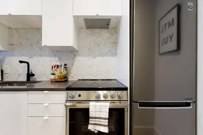 a kitchen with a stainless steel stove and a sink at Blue Tropics Studio in Little Italy with kitchen by Den Stays in Montréal