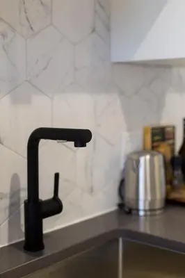 a kitchen sink with a black kitchen faucet at Scandinavian Studio with Full Kitchen and Bath by Den Stays in Montréal