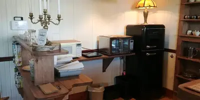 a kitchen with a counter with a microwave and a refrigerator at Au Coeur des Jardins in Compton