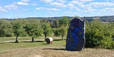 a statue in a field with a sheep in the background at Au Coeur des Jardins in Compton