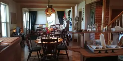 a dining room with a wooden table and chairs at Au Coeur des Jardins in Compton