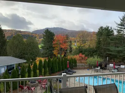 a balcony with a view of a pool and trees at Le Champlain Condo-Hôtel in Bromont