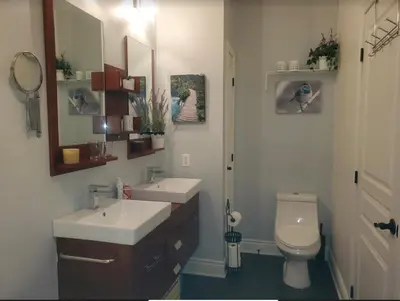 a bathroom with two sinks and a toilet and a mirror at Le Champlain Condo-Hôtel in Bromont