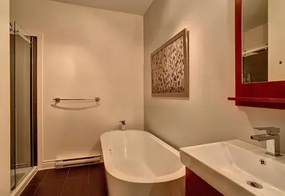 a bathroom with a white tub and a sink at Le Champlain Condo-Hôtel in Bromont