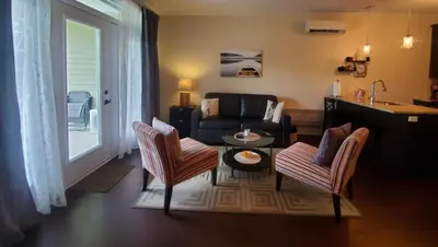 a living room with a couch and chairs and a table at Le Champlain Condo-Hôtel in Bromont