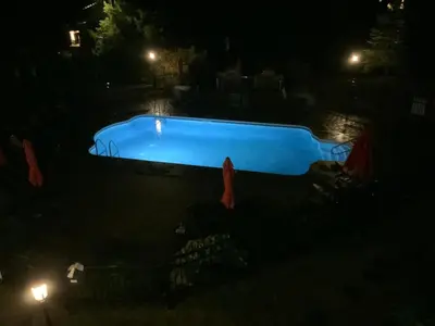 a blue swimming pool at night with lights at Le Champlain Condo-Hôtel in Bromont