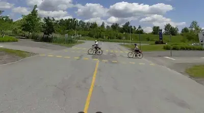 two people riding bikes down a street at Le Paréo de Magog-Mont Orford in Magog-Orford