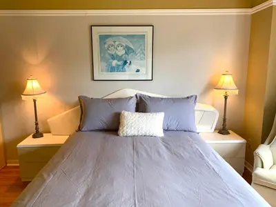 a bedroom with a large bed with two lamps at Le Paréo de Magog-Mont Orford in Magog-Orford