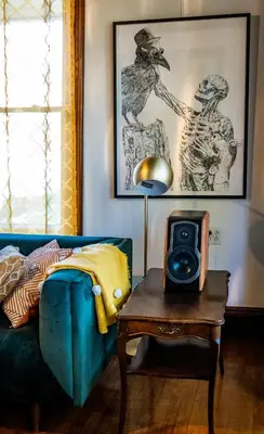 a room with a bed and a table with a speaker at Au Loup, maison élégante in Waterloo