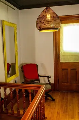 a room with a chair and a mirror and a lamp at Au Loup, maison élégante in Waterloo