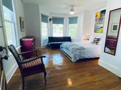 a bedroom with a bed and a chair and a couch at Au Loup, maison élégante in Waterloo