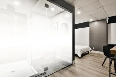 a bedroom with a glass door leading to a bed at Hygie Boutique Hotel in Montréal