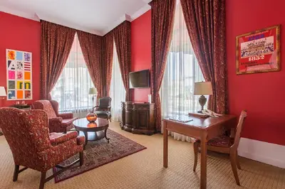 a living room with red walls and a desk and chairs at LHotel in Montréal