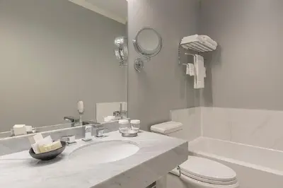 a bathroom with a sink and a toilet and a mirror at LHotel in Montréal