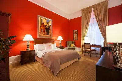 a bedroom with red walls and a bed and a desk at LHotel in Montréal