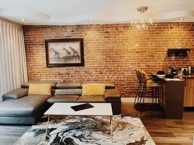 a living room with a couch and a brick wall at Hotel Kutuma in Montréal