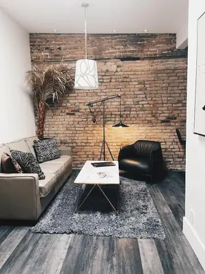 a living room with a couch and a brick wall at Hotel Kutuma in Montréal