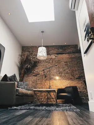 a brick wall in a living room with a couch and a table at Hotel Kutuma in Montréal