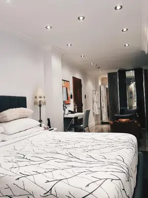 a bedroom with a large bed and a desk at Hotel Kutuma in Montréal