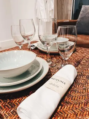 a table with wine glasses and plates and a napkin at Hotel Kutuma in Montréal