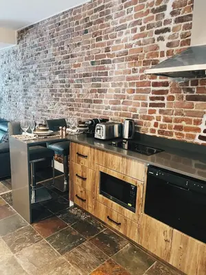 a kitchen with a counter and a brick wall at Hotel Kutuma in Montréal