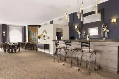 a restaurant with a bar with chairs and tables at Days Inn by Wyndham Montreal Airport Conference Centre in Dorval