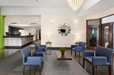 a lobby with blue chairs and a table at Days Inn by Wyndham Montreal Airport Conference Centre in Dorval