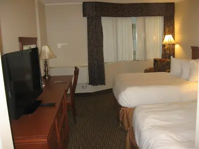 a hotel room with two beds and a flat screen tv at Hotel Chrome Montreal Centre-Ville in Montréal