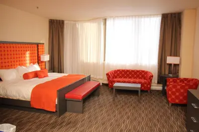 a hotel room with a bed and a chair at Hotel Chrome Montreal Centre-Ville in Montréal