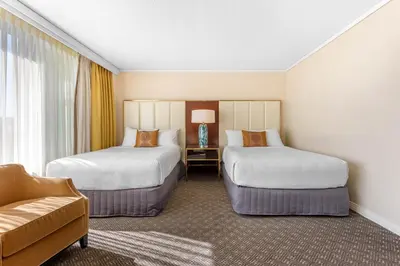 a hotel room with two beds and a couch at Omni Mont-Royal Hotel in Montréal