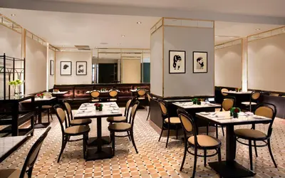 a restaurant with tables and chairs in a room at Omni Mont-Royal Hotel in Montréal
