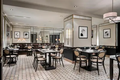 a restaurant with tables and chairs and a bar at Omni Mont-Royal Hotel in Montréal