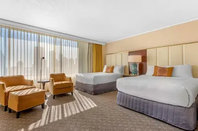 a hotel room with two beds and a chair at Omni Mont-Royal Hotel in Montréal