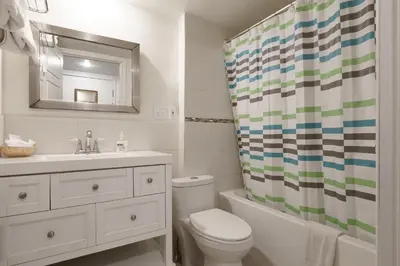 a bathroom with a sink toilet and a shower curtain at Hotel Auberge Manoir Ville Marie in Montréal