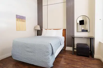 a hotel room with a bed and a mirror at Hotel Auberge Manoir Ville Marie in Montréal