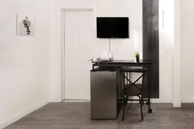 a room with a desk with a chair and a television at Hotel Auberge Manoir Ville Marie in Montréal