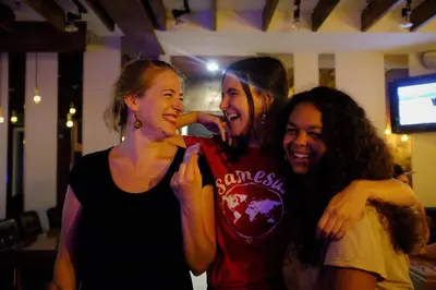 three young women standing next to each other at a party at Samesun Montreal Hotel & Hostel in Montréal