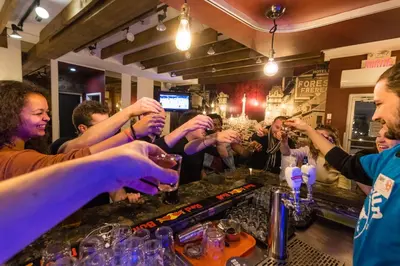 a group of people drinking at a bar at Samesun Montreal Hotel & Hostel in Montréal