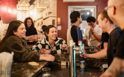 a group of people sitting at a bar at Samesun Montreal Hotel & Hostel in Montréal