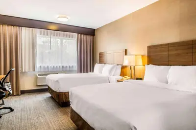 a hotel room with two beds and a window at Quality Hotel Dorval Aeroport in Dorval