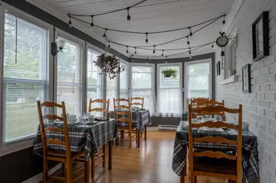 a dining room with a table and chairs at Au coq du bonheur in Magog-Orford