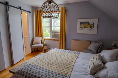 a bedroom with a large bed and a window at Au coq du bonheur in Magog-Orford