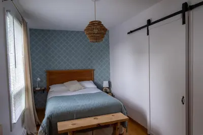 a bedroom with a bed and a pendant light at Au coq du bonheur in Magog-Orford